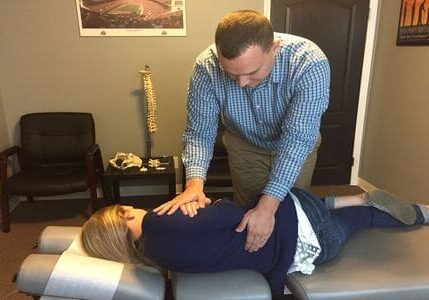 A man and woman are in the process of having their back examined.